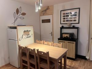 a dining room with a table and a refrigerator at Appartement Villar d'arène in Villar-dʼArène