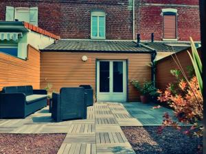 a patio with a couch and chairs in front of a building at citesteloi in Friville-Escarbotin +13 photos