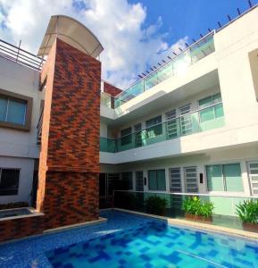 a building with a swimming pool in front of a building at Perla del Carbie Casa 11 Hab Vista al mar y sierra in Santa Marta