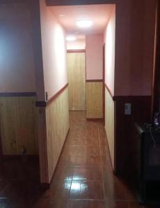 an empty hallway with wooden doors and a tile floor at Descanso llafenco in Minetué