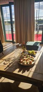 Una mesa con dos platos de comida y copas de vino. en Leśny Azyl Parczów, en Parczów