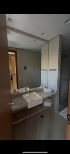 a bathroom with a sink and a large mirror at Apartamento 34 in Pirenópolis