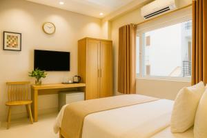 a bedroom with a bed and a desk and a television at Anh Hotel in Ho Chi Minh City