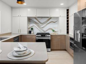 a kitchen with white cabinets and a table with a bowl on it at Modern Midtown in Yegen