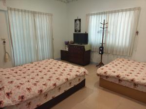 a bedroom with two beds and a television in it at Harmony Village in Wujie