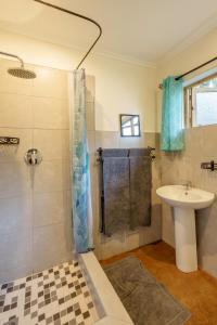a bathroom with a shower and a sink at Zambezi River Cottages in Livingstone +24 photos
