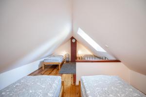 a attic room with two beds and a staircase at Bedřichov U Nás in Bedřichov
