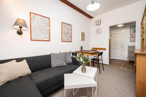 a living room with a black couch and a table at Bedřichov U Nás in Bedřichov +6 photos