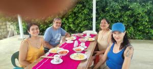 un gruppo di persone sedute a un tavolo che mangiano cibo di Hostal Cultural El Telar a San Jacinto