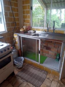 een keuken met een spoelbak en een aanrechtblad bij Casa aconchegante em cotijuba in Ilha Paquetá-Açu