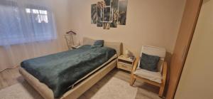 a small bedroom with a bed and a chair at Bella Z Apartman in Kaposvár