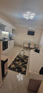 a living room with a bed and a kitchen with a table at Bella Z Apartman in Kaposvár