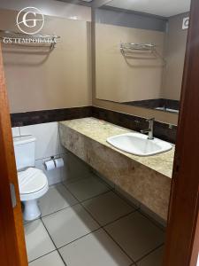 une salle de bain avec un lavabo et des toilettes dans l'établissement Le jardin Caldas Novas, à Caldas Novas 37 autres photos