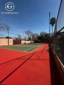 a tennis court with a net on a tennis court at Hotel suits Le jardin in Caldas Novas