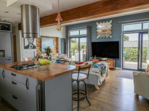 a kitchen and living room with a stove top oven at Coogee View in New Quay