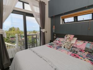 a bedroom with a bed and a balcony at Coogee View in New Quay