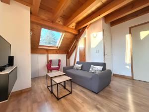 - un salon avec un canapé et un fauteuil rouge dans l'établissement Chez Fred 202 - Parking Wifi Balcon, à Saint-Pierre-dʼAlbigny