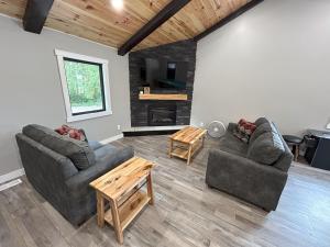 a living room with two couches and a fireplace at The Farmhouse at Rustic Ridge in Benzonia