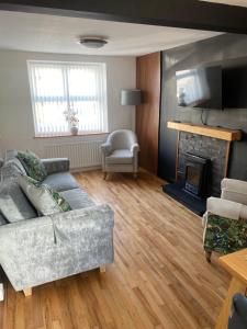 a living room with a couch and a fireplace at Tea Lane Cottage in Carnlough
