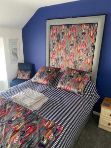 a bedroom with a bed with a floral headboard at Tea Lane Cottage in Carnlough
