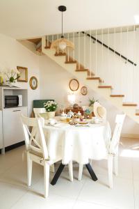 a white dining room with a white table and chairs at Casa Paola in Borso del Grappa