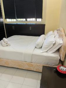 a bed with white sheets and pillows in a bedroom at Homestay bukit bayu in Sungai Petani