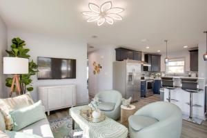 Sunny Fort Myers Home Golf, Shop and Relax! في فورت مايرز: غرفة معيشة مع كراسي زرقاء ومطبخ