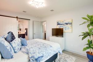 Sunny Fort Myers Home Golf, Shop and Relax! في فورت مايرز: غرفة نوم مع سرير ووسائد زرقاء وتلفزيون