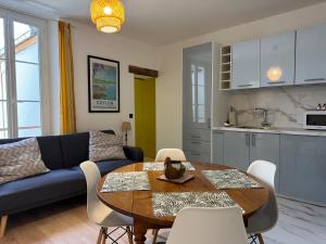 a living room with a blue couch and a table at Le Papagallo in Montargis