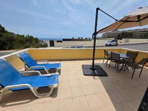 un gruppo di sedie e un ombrellone su un tetto di Apartamento Sol e Mar Sesimbra a Sesimbra