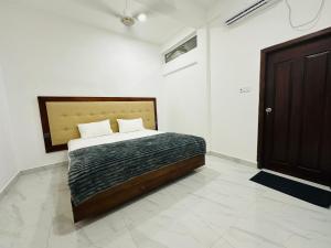 a bedroom with a bed in a white room at Nallur Heritage Villa in Jaffna