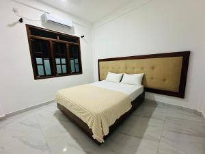 a bedroom with a bed in a room with a window at Nallur Heritage Villa in Jaffna