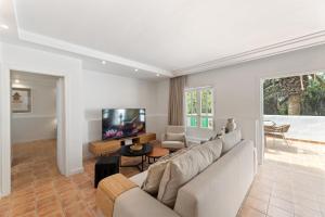 a living room with a couch and a tv at Oasis del Marinero by EscapeHome in Costa Teguise +28 photos