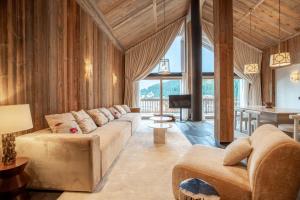 Una sala de estar con un sofá, un televisor y una mesa. en Antarès SIRIUS 501 - Rooftop penthouse ski inski out apartment, en Méribel