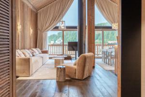 una sala de estar con un sofá y una silla en Antarès SIRIUS 501 - Rooftop penthouse ski inski out apartment, en Méribel