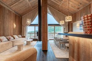 una sala de estar con un sofá y una mesa en Antarès SIRIUS 501 - Rooftop penthouse ski inski out apartment, en Méribel