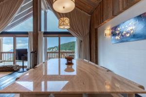 Una sala de estar con una mesa y una gran ventana. en Antarès SIRIUS 501 - Rooftop penthouse ski inski out apartment, en Méribel