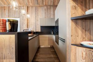 cocina con paredes de madera y suelo de madera en Antarès SIRIUS 501 - Rooftop penthouse ski inski out apartment, en Méribel 31 fotos más