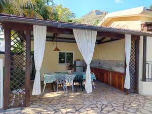 a patio with a table with chairs and a kitchen at Tamarin chambre d'Hôtes in Tamarin