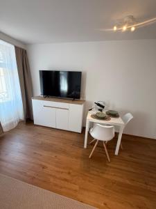 a living room with a small table and a tv at Studio mit Balkon im Zentrum in St. Gallen