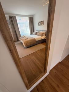 a mirror reflecting a bedroom with a bed in a room at Studio mit Balkon im Zentrum in St. Gallen