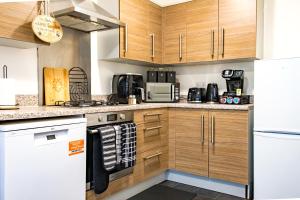 a kitchen with white appliances and wooden cabinets at Serene Contractor Pad - Slough, Heathrow, Windsor - Free Parking- WiFi - Sleeps 6-7 in Slough