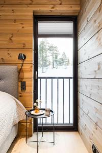 a room with a bed and a table with a window at Stay North - Utsunkajo in Kittilä