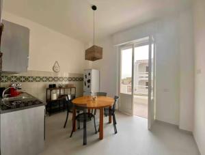a kitchen with a wooden table and a kitchen with a refrigerator at Casa Carmela in Cozze
