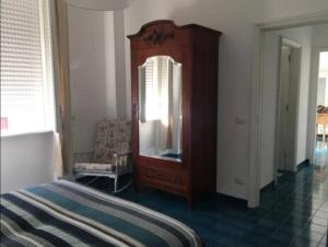 a bedroom with a wooden dresser and a mirror at Casa Carmela in Cozze