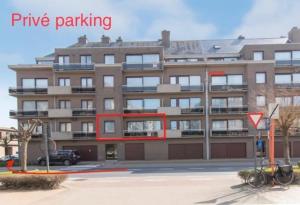 a large building with a parking lot in front of it at Westhelling Middelkerke in Middelkerke
