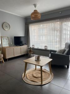 a living room with a couch and a coffee table at Westhelling Middelkerke in Middelkerke