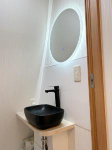 a bathroom with a black sink and a mirror at Ikebukuro center#池袋中心#高级阳光公寓车站步行5分#高速wifi#智能马桶干湿分离1201 in Tokyo