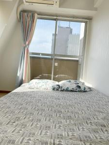a bed in a room with a window and a bedspread at Ikebukuro center#池袋中心#高级阳光公寓车站步行5分#高速wifi#智能马桶干湿分离1201 in Tokyo +5 photos