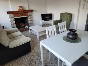Una sala de estar con mesa y sillas y una chimenea. en Casa Real, en El Arenal
